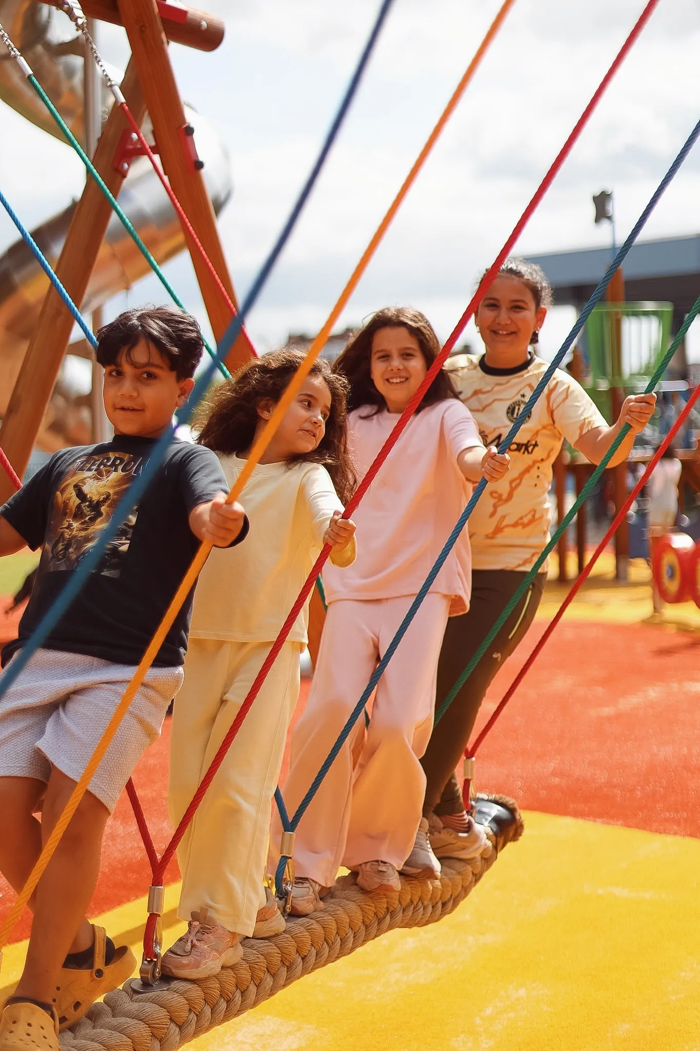 Vier kinderen die lachend samen spelen in de speeltuin van Spelen bij Beelen